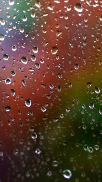 Glas Mit Regentropfen Wassertropfen Auf Fenster Auf Verschwommenem Buntem Hintergrund — Stockvideo