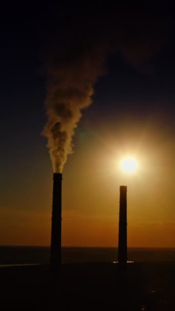 黑暗中制造业冒出的烟在落日背景上有化学排放物的工业管道 污染环境 垂直录像 — 图库视频影像