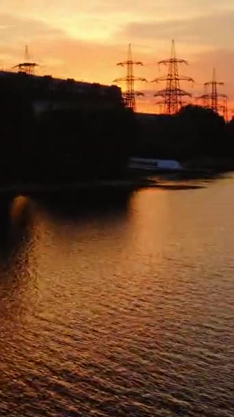 夕方には水に近い有害な産業が存在する 日没の川の近くの工業地帯のダークシルエット 自然の中で製造する 空からの眺め バーティカルビデオ — ストック動画