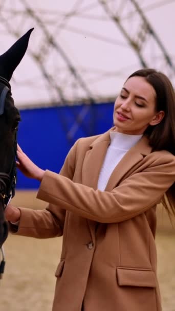Piękna Brunetka Beżowej Kurtce Trzymająca Pięknego Czarnego Konia Kobieta Prowadząca — Wideo stockowe