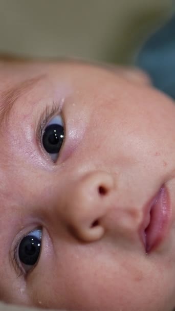 カメラに注意深く見ている素敵な甘い赤ちゃん かわいい小さな子供が優しく微笑んでいる クローズアップ バーティカルビデオ — ストック動画