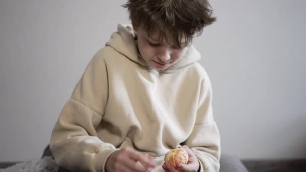 진정한 코카서스 Tangerine 소년은 천천히 과일을 껍질을 조각으로 나눕니다 — 비디오