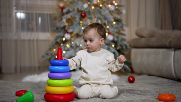 Kedves Kaukázusi Baba Játékpiramist Épít Kisgyerek Padlón Nem Messze Karácsonyfájától — Stock videók