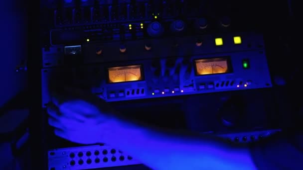 蓝光下的录音室录音设备 男性音频工程师的手在立体声面板上工作 俯瞰近景 — 图库视频影像