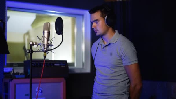 Όμορφος Άντρας Ακουστικά Στο Κεφάλι Στέκεται Στο Στούντιο Ηχογράφησης Τραγουδιστής — Αρχείο Βίντεο