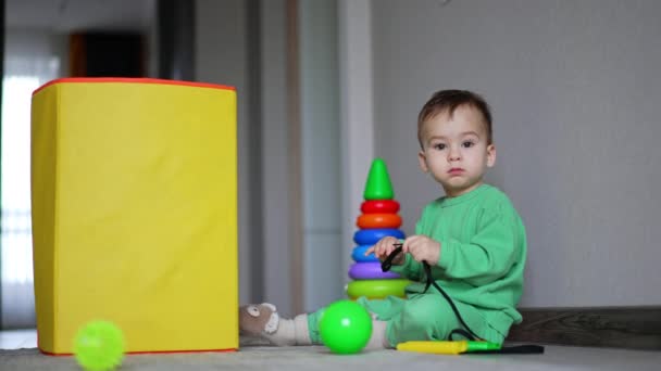 Calm Caucasian Child Sits Floor Playing Black Cord Balls Pyramid — Stock Video