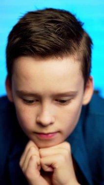 Kameraya dik dik bakan üzgün bir çocuğun portresi.