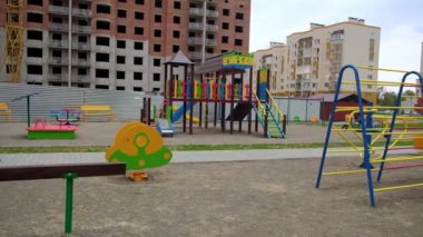 Konut alanında geniş bir oyun alanı var. Arkaplanda inşaatta bir ev. Şehrin yeni yerleşim bölgesi..