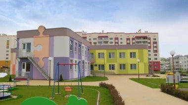 Yeni inşa edilmiş anaokulunun güzel binaları. Çok güzel korunan bir bölge. Sevimli oyun alanı ve salıncakları var..