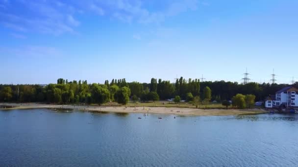 水から川の岸に近づく ビーチで休んで水泳をしている人たち 晴れた日の映像 — ストック動画