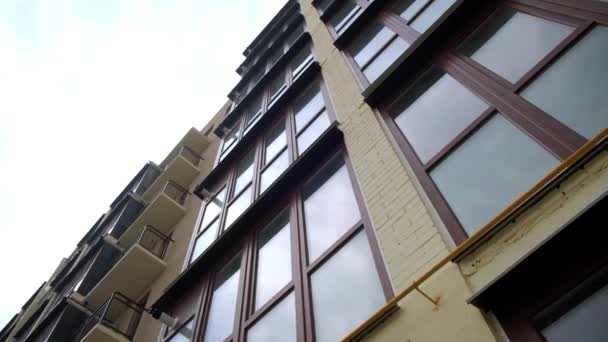 新建成的住宅大楼正面的玻璃阳台和开放的阳台 灰色天空背景下的当代住宅 低角度视图 — 图库视频影像