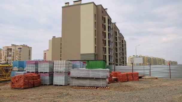 フラットの複数のブロックの新しい住宅地の建設 未完成の家を背景としたクレーンや建材 — ストック動画