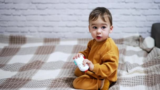 Boldog Aranyos Kaukázusi Kisgyerek Ágyon Aranyos Gyermek Kezében Tartja Játéktelefonját — Stock videók