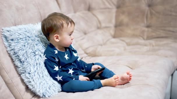Niedliche Kaukasische Kleinkind Sitzt Friedlich Auf Dem Sofa Kind Hält — Stockvideo