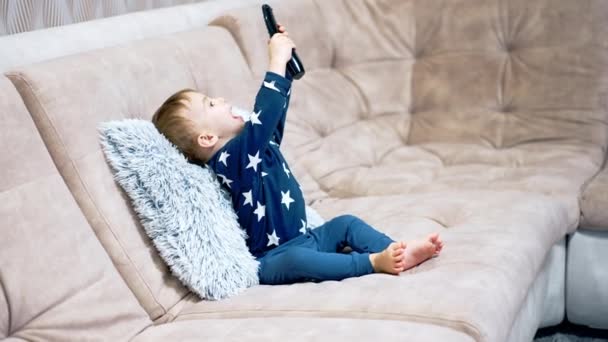 Schöne Kleine Kleinkind Blauen Kleidern Sitzt Auf Einem Großen Sofa — Stockvideo