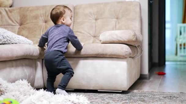 Sweet Kid Stands Holding Sofa Lovely Child Walks Happily Corridor — Stock Video
