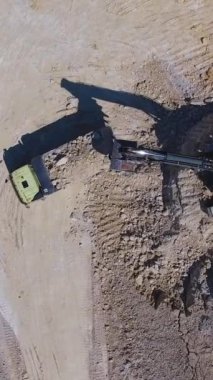 Taş ocağının bölgesindeki kaolin kilini küreyen modern kazıcı. Yüklü kamyon sanayi tesisi için bölgeden ayrılıyor. Dikey video