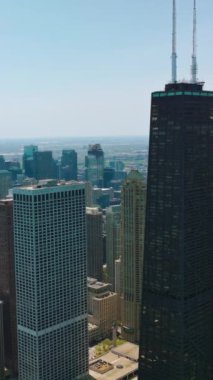 Yüksek karanlık gökdelen diğer mimarinin yanında duruyor. Güneşli bir günde Şikago 'daki çarpıcı hava aracı görüntüleri. Dikey video