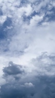 Bulutlar gökyüzünü tamamen kaplıyor. Hafif bulutlar yağmur bulutları oluşturmak için toplanıyor. Zaman ayarlı. Düşük açı. Dikey video