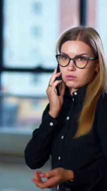 İşle ilgili tatsız bir telefon görüşmesi. Sinirli bayan telefon konuşmasından memnun değil ve görüşmeyi bitiriyor. Masadaki meslektaşlar arka planda bulanık duruyor. Dikey video