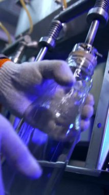 Cam şişeler otomatik dolum sisteminin altına konuyor. Modern gıda fabrikasının şişelerine taze yapılmış elma suyu döküldü. Dikey video