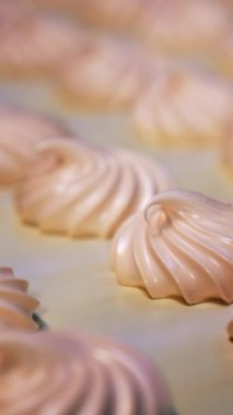 Taze marşmelovlu taşıma bandı. Kremalı tatlılara yakından bir bak. Arka plan bulanık. Dikey video