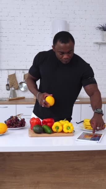 브라니 건강한 아프리카 남자는 부엌에있다 패드를 사용하는 과일을 선택하는 잘생긴 — 비디오
