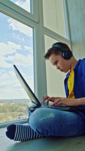 Szczęśliwy Chłopak Słuchawkach Laptopem Domu Uczeń Siedzi Przy Oknie Radośnie — Wideo stockowe