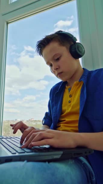 Adolescente Fones Ouvido Com Laptop Pela Janela Menino Concentrado Pressionando — Vídeo de Stock