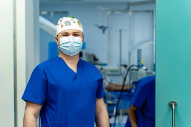 Üniformalı ve maskeli yakışıklı doktorun portresi. Tıp hastanesi pratisyeni.