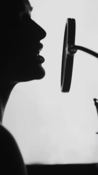 在录音室唱歌的女人一个漂亮的脸蛋和嘴唇的女人的特征 黑白垂直录像 — 图库视频影像