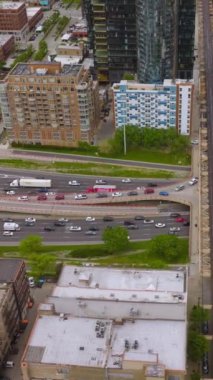 Chicago, Illinois 'deki yollar, hava yolları ve köprüler boyunca sayısız araba hareket ediyor. Modern metropolde çılgın bir trafik var. Üst Manzara. Dikey video