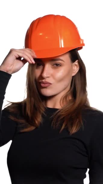 Красивая Женщина Оранжевом Шлеме Черном Гольфе Позирует Перед Камерой Белом — стоковое видео