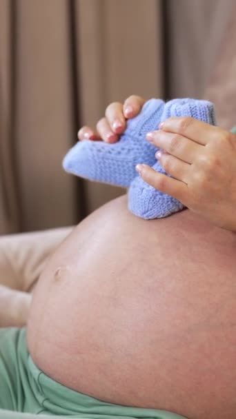 Gravid Kvinna Hålla Par Söta Baby Strumpor Hennes Nakna Mage — Stockvideo