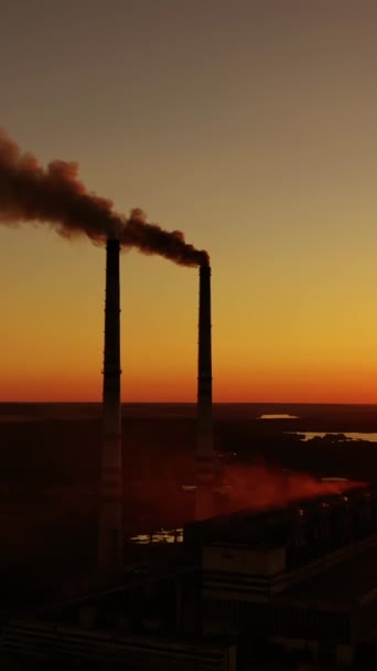 空气污染 日落时工业管道冒出浓烟 在夕阳西下 河畔有害工厂的轮廓 垂直录像 — 图库视频影像
