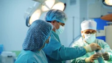 Modern ameliyathanede tıbbi ekip çalışıyor. Bir grup doktor cerrahi prosedüre hazırlanıyor..