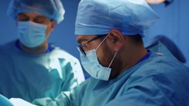 Maskeli beyaz sakallı cerrah fiziksel olarak çok çalışıyor. Yan görüş. Modern kliniklerde travma cerrahı.