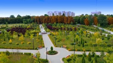 Güzel mimarisi olan şehir parkı. İnsansız hava aracı bahçede uçuyor ve sonra yerleşim bölgesine uçuyor..