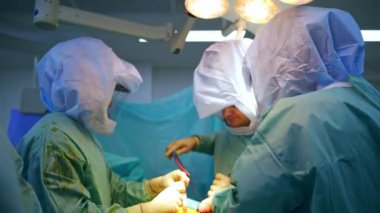 Travma cerrahisi uzmanı. Koruyucu giysili doktorlar işlerinde metal aletler kullanırlar..