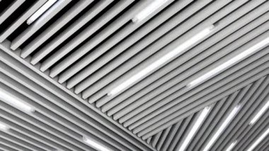 Tavanda beyaz gün ışığı için lambalar bulunan dekorasyon tahtaları. Siyah beyaz görüntü. Düşük açı görünümü.