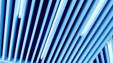 Tavandaki dekoratif kalasların arasında beyaz gün ışığından uzun lambalar. Düşük açı perspektifinden çember hareketi.