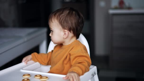 Bonito Menino Cabelos Escuros Senta Uma Mesa Alimentação Com Bagels — Vídeo de Stock