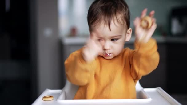 Boldog Egy Éves Csecsemő Integet Kezével Étkezés Közben Baba Figyeli — Stock videók