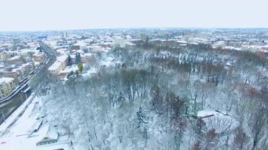 Kış mevsiminde kar altında bir şehir. Yüksek manzaralı binalar, parklar ve yollar olan güzel bir şehir manzarası..