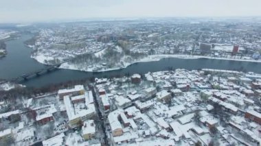 Çarpık nehir büyük şehri iki parçaya ayırıyor. Soğuk, karlı kış gününde şehir panoraması. Üst görünüm.