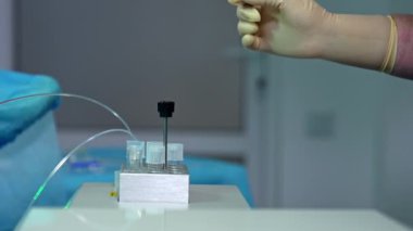 Test tüplerini dolduran sıvılar. Depoyu doldurmak için eldivenli sıhhiyecinin eli. Kapatın. Bulanık arkaplan.