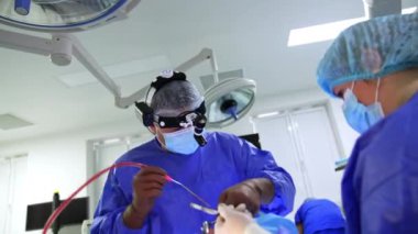 Profesyonel cerrah tarafından yapılan burun ameliyatı. Doktor cihaz kullanıyor ve tüp çalışıyor. Düşük açı görünümü.