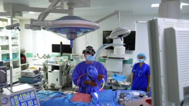 Cerrah otolaringolojist hastanın burun boşluğuna aletler uyguluyor. Doktor dikkatle onun önündeki ekrana bakıyor..