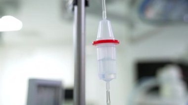 Ameliyat odasında asılı duran tezgaha sıvı damlıyor. Kapatın. Bulanık arkaplan.