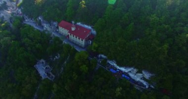 Yeşilliklerle kaplı kayanın üzerindeki inanılmaz manastır. Üzerinde dini binalar olan beyaz kaya oluşumları. Üst görünüm.